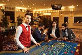 Dealer marsbahis menunjukkan kartu komunitas di meja Casino Hold'em